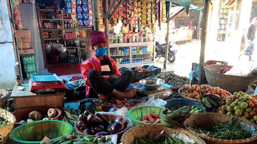 A shopkeeper in Bangladesh wearing a mask provided as part of the study 